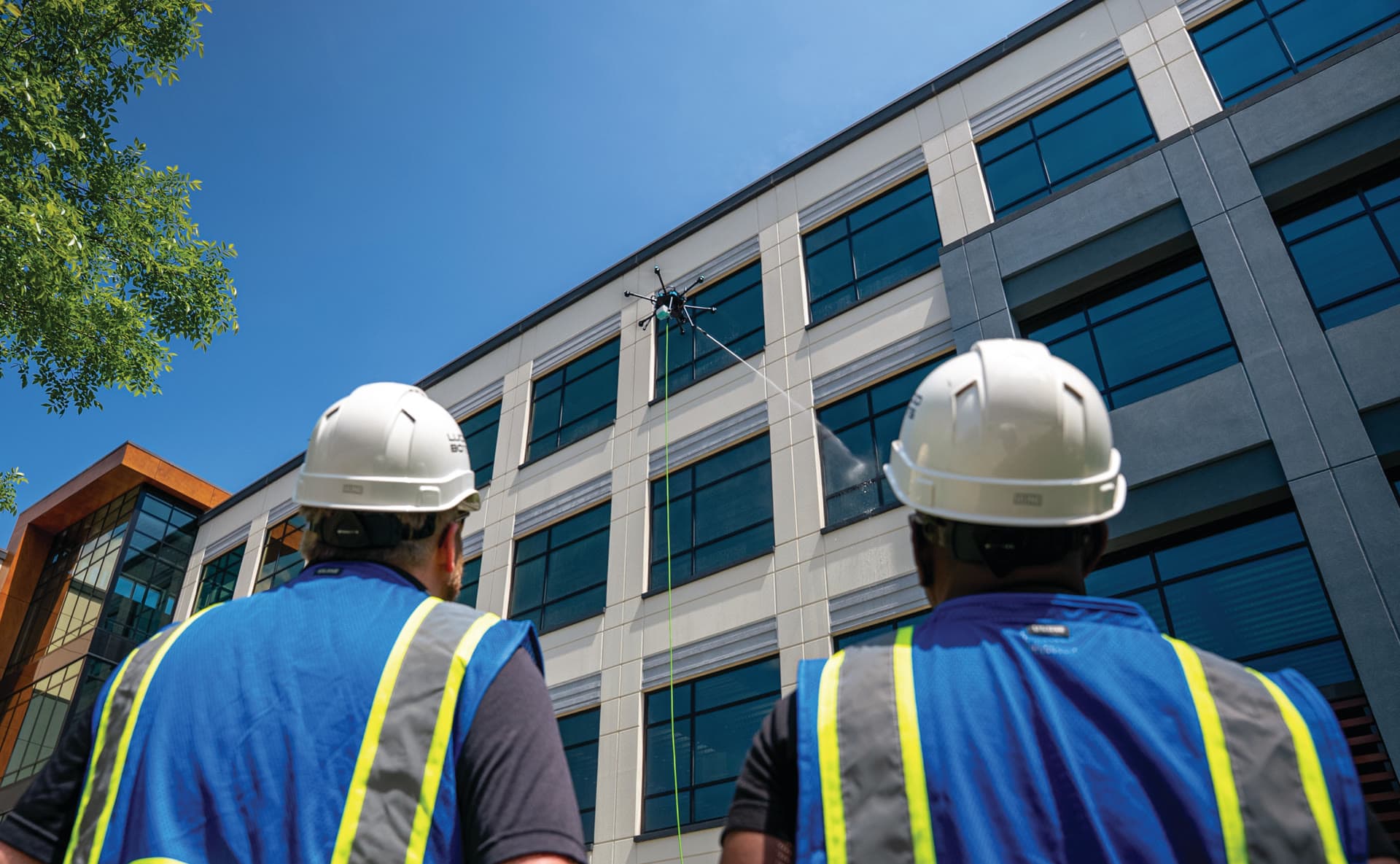 Clear Edge crew watching drone clean a multi-story building